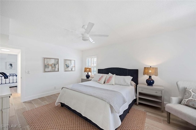 3070 Gulf Shore Blvd N Unit 104, Naples, FL 34103 - bedroom with light wood-type flooring, a ceiling fan, and a textured ceiling