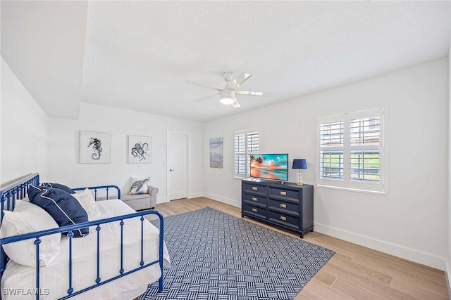 3070 Gulf Shore Blvd N Unit 104, Naples, FL 34103 - bedroom with light wood-style flooring, a ceiling fan, and a textured ceiling