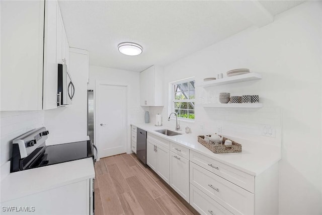 3070 Gulf Shore Blvd N Unit 104, Naples, FL 34103 - kitchen with stainless steel appliances, backsplash, white cabinetry, and light wood finished floors