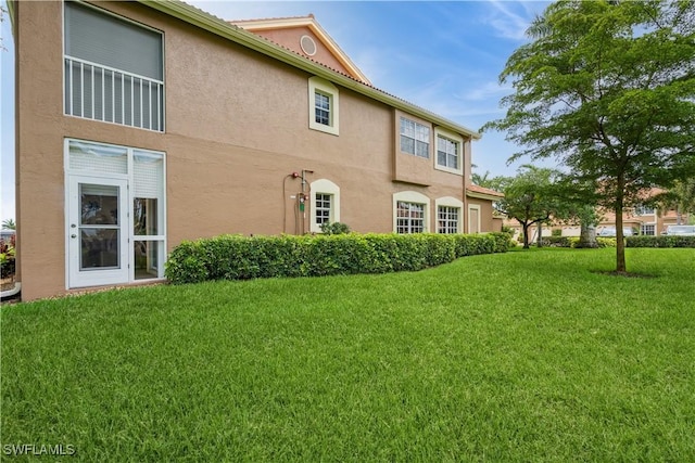 13221 Sherburne Cir Unit 601, Bonita Springs, FL 34135 - back of property with a yard and stucco siding