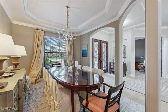 3441 Runaway Ln, Naples, FL 34114 - dining space with arched walkways, a chandelier, ornamental molding, a raised ceiling, and french doors