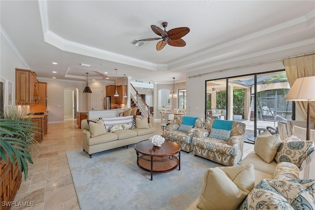 3441 Runaway Ln, Naples, FL 34114 - living room with a raised ceiling, a ceiling fan, crown molding, light stone finish flooring, and stairway