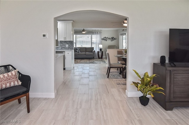 1721 Cascade Way N, Fort Myers, FL 33917 - living area featuring a ceiling fan, arched walkways, and light wood-style flooring