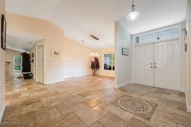 6011 Sea Grass Ln, Naples, FL 34116 - foyer entrance with stone tile flooring, lofted ceiling, a chandelier, and plenty of natural light