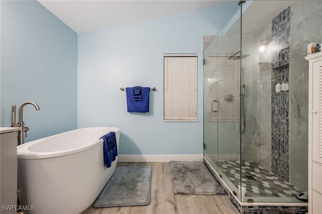 6011 Sea Grass Ln, Naples, FL 34116 - bathroom with wood finished floors, a freestanding bath, and a stall shower