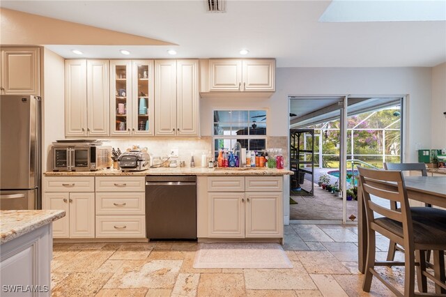 6011 Sea Grass Ln, Naples, FL 34116 - kitchen with appliances with stainless steel finishes, stone tile flooring, recessed lighting, decorative backsplash, and light stone counters