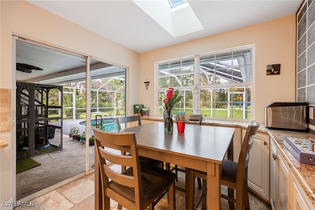 6011 Sea Grass Ln, Naples, FL 34116 - dining area featuring a sunroom, a skylight, and stone tile floors