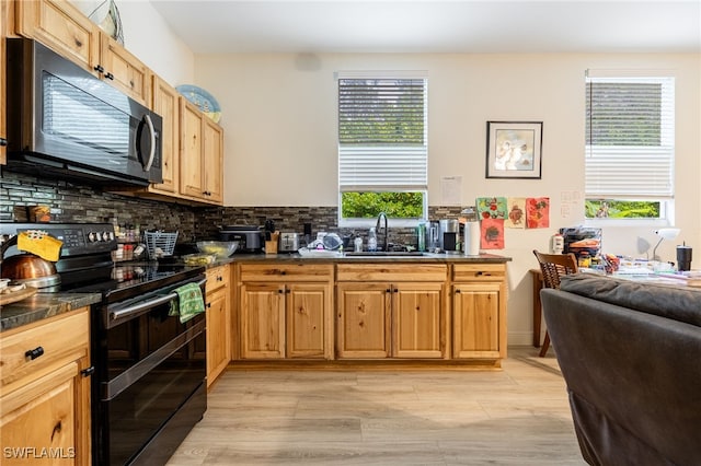 6011 Sea Grass Ln, Naples, FL 34116 - kitchen featuring black appliances, dark countertops, decorative backsplash, and light wood-style floors