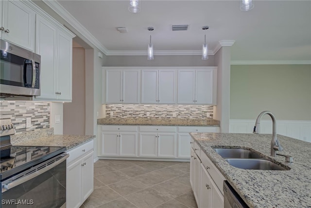1964 Parson St, Naples, FL 34120 - kitchen featuring stainless steel microwave, range with electric stovetop, hanging light fixtures, crown molding, and white cabinets