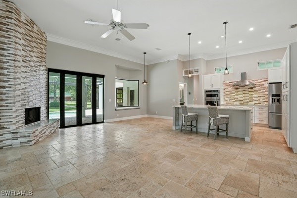 4740 5th Ave SW, Naples, FL 34119 - kitchen with stainless steel appliances, stone tile floors, light countertops, recessed lighting, and white cabinets