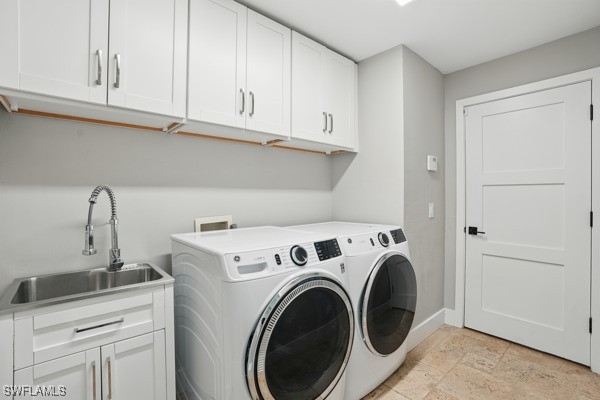 4740 5th Ave SW, Naples, FL 34119 - washroom with cabinet space, washer and clothes dryer, and light stone finish flooring