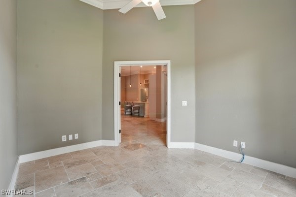 4740 5th Ave SW, Naples, FL 34119 - empty room featuring a high ceiling, a ceiling fan, crown molding, and light stone finish floors