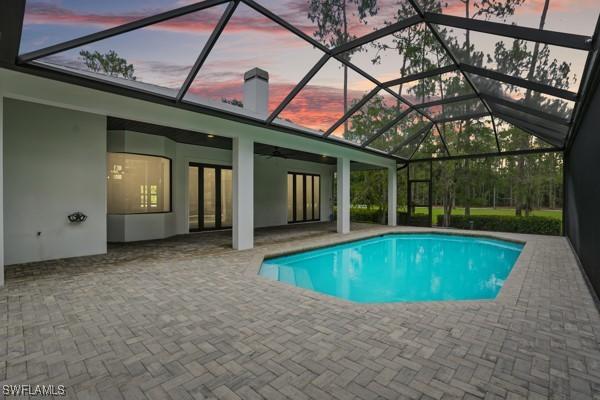 4740 5th Ave SW, Naples, FL 34119 - pool at dusk featuring a patio area, an outdoor pool, and ceiling fan