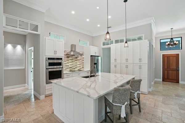 4740 5th Ave SW, Naples, FL 34119 - kitchen featuring appliances with stainless steel finishes, stone tile flooring, wall chimney exhaust hood, ornamental molding, and white cabinets