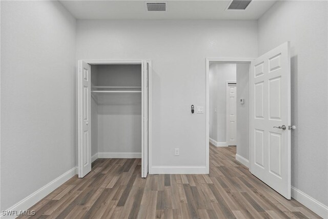 311 Long Ave S, Lehigh Acres, FL 33974 - unfurnished bedroom featuring wood finished floors and a closet