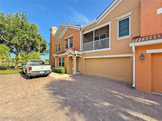 1837 Concordia Lake Cir Unit 1204, Cape Coral, FL 33909 - view of property featuring stucco siding, an attached garage, a tiled roof, and driveway