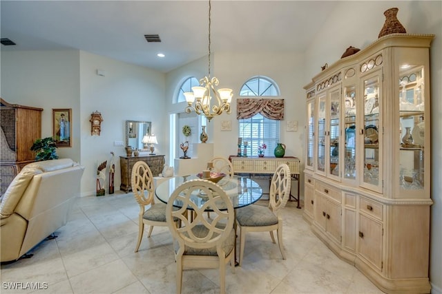 17791 Pineapple Palm Ct, North Fort Myers, FL 33917 - dining area with a chandelier, light tile patterned floors, and a towering ceiling