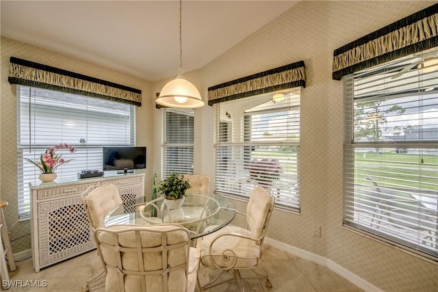 17791 Pineapple Palm Ct, North Fort Myers, FL 33917 - dining space with wallpapered walls, light tile patterned flooring, lofted ceiling, and plenty of natural light