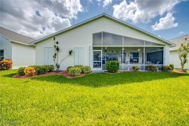 17791 Pineapple Palm Ct, North Fort Myers, FL 33917 - back of house with stucco siding, a sunroom, and a lawn