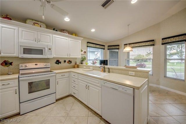 17791 Pineapple Palm Ct, North Fort Myers, FL 33917 - kitchen featuring white appliances, lofted ceiling, a peninsula, white cabinetry, and light countertops