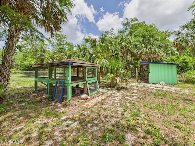 490 25th St SW, Naples, FL 34117 - view of yard featuring exterior structure, an outbuilding, and view of wooded area