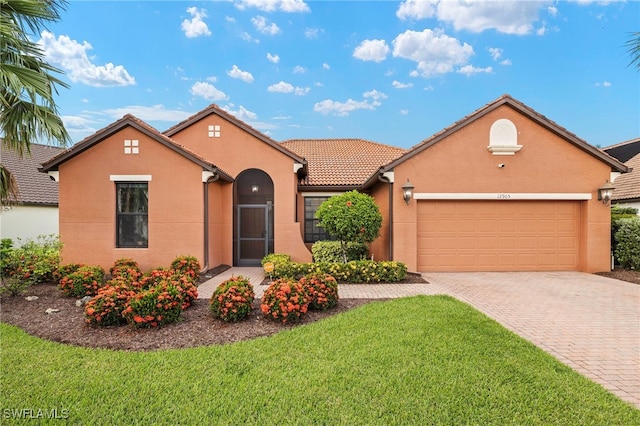 12905 Pastures Way, Fort Myers, FL 33913 - view of front of house featuring stucco siding, decorative driveway, a front yard, an attached garage, and a tile roof