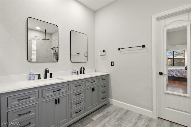12905 Pastures Way, Fort Myers, FL 33913 - bathroom featuring double vanity, a walk in shower, wood finished floors, and ensuite bathroom