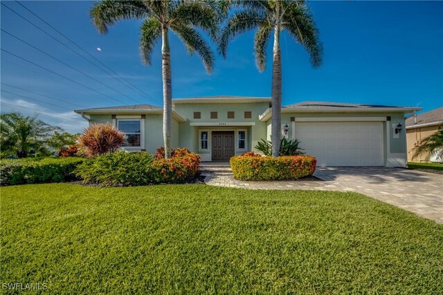 2102 SW 47th St, Cape Coral, FL 33914 - view of front facade with stucco siding, an attached garage, a front lawn, and driveway