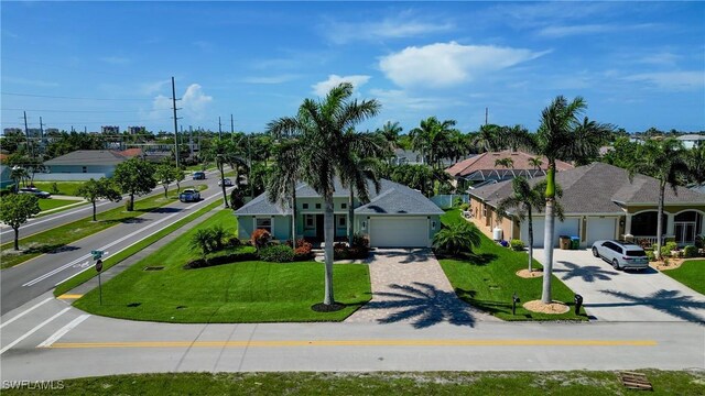 2102 SW 47th St, Cape Coral, FL 33914 - view of front of home with driveway, a garage, a front yard, and a residential view