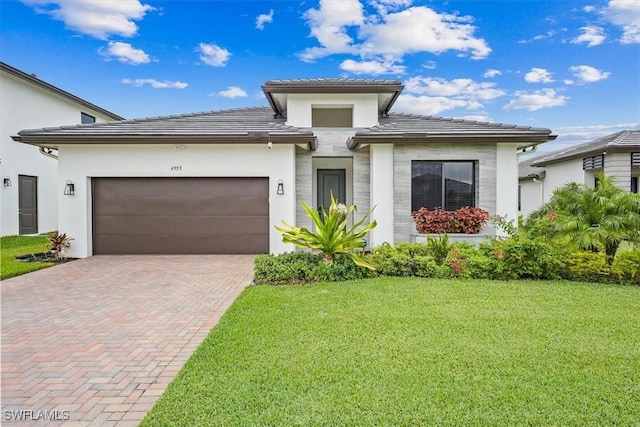 4955 Brigata Way, Ave Maria, FL 34142 - prairie-style house with decorative driveway, a front yard, an attached garage, and stucco siding