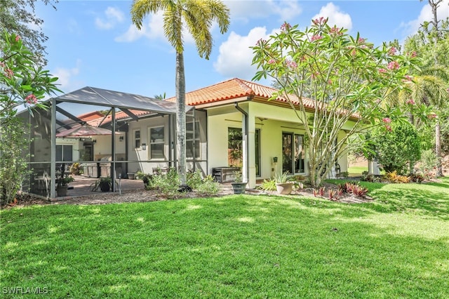 4000 Stonesthrow Ct, Naples, FL 34109 - back of house with a tiled roof, a yard, stucco siding, and glass enclosure
