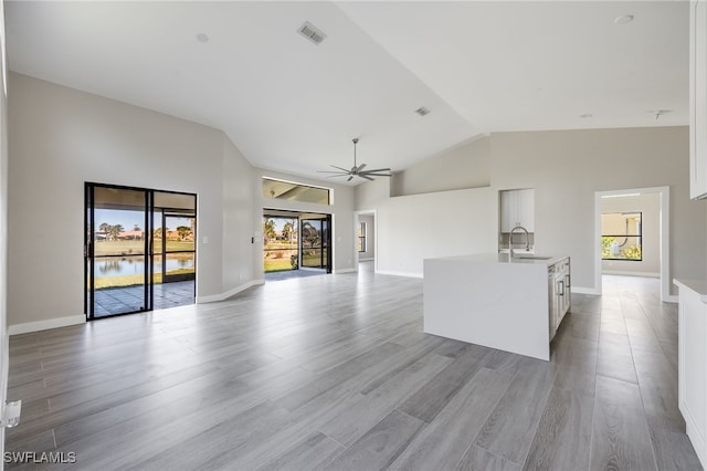 12730 Kelly Palm Dr, Fort Myers, FL 33908 - unfurnished living room with healthy amount of natural light, light wood-style flooring, a ceiling fan, and high vaulted ceiling