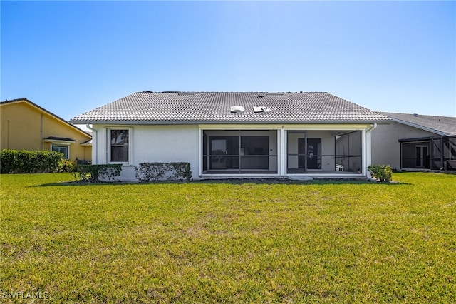 12730 Kelly Palm Dr, Fort Myers, FL 33908 - back of house featuring a lawn, a tile roof, stucco siding, and a sunroom