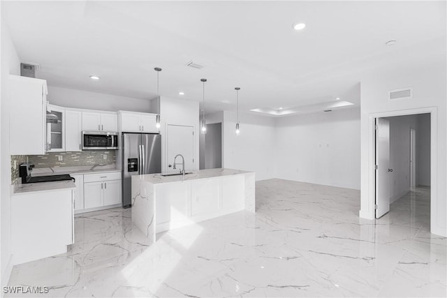 7029 Palpano Cir, Labelle, FL 33935 - kitchen featuring appliances with stainless steel finishes, recessed lighting, backsplash, white cabinets, and an island with sink