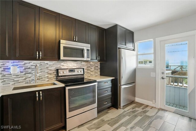 5557 Estero Blvd, Fort Myers Beach, FL 33931 - kitchen with appliances with stainless steel finishes, tasteful backsplash, light countertops, and dark brown cabinets