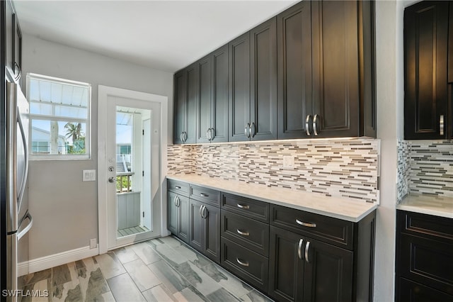 5557 Estero Blvd, Fort Myers Beach, FL 33931 - kitchen featuring light countertops, decorative backsplash, and freestanding refrigerator