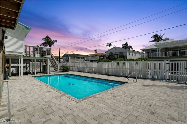 5557 Estero Blvd, Fort Myers Beach, FL 33931 - pool at dusk featuring stairs, a patio area, and a fenced backyard