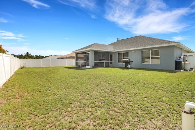 3211 NE 14th Pl, Cape Coral, FL 33909 - back of property with a sunroom, a fenced backyard, roof with shingles, and stucco siding