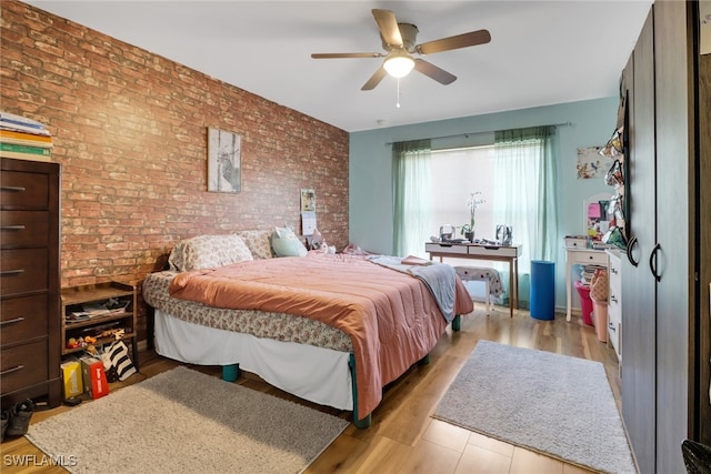 3211 NE 14th Pl, Cape Coral, FL 33909 - bedroom featuring brick wall, light wood-style floors, and ceiling fan