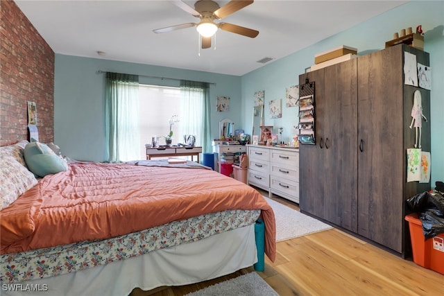 3211 NE 14th Pl, Cape Coral, FL 33909 - bedroom featuring light wood-style floors, a ceiling fan, and brick wall