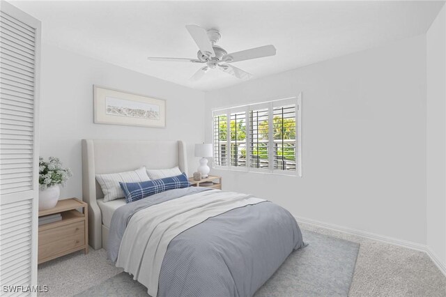 3052 Kings Lake Blvd Unit 7554, Naples, FL 34112 - bedroom featuring a ceiling fan and light colored carpet