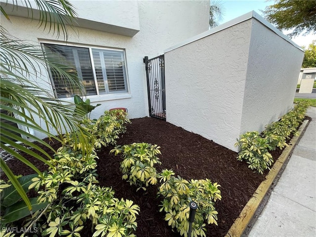 3052 Kings Lake Blvd Unit 7554, Naples, FL 34112 - view of home's exterior featuring stucco siding and a gate