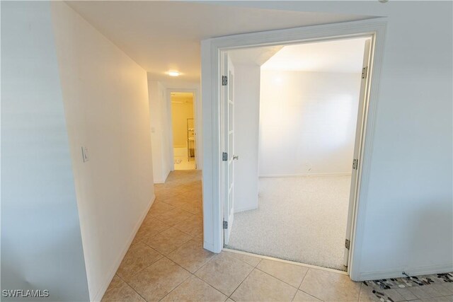 3052 Kings Lake Blvd Unit 7554, Naples, FL 34112 - hallway featuring light tile patterned flooring and light carpet