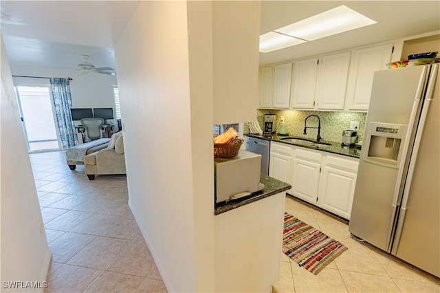 3052 Kings Lake Blvd Unit 7554, Naples, FL 34112 - kitchen with appliances with stainless steel finishes, light tile patterned flooring, dark stone countertops, decorative backsplash, and white cabinets