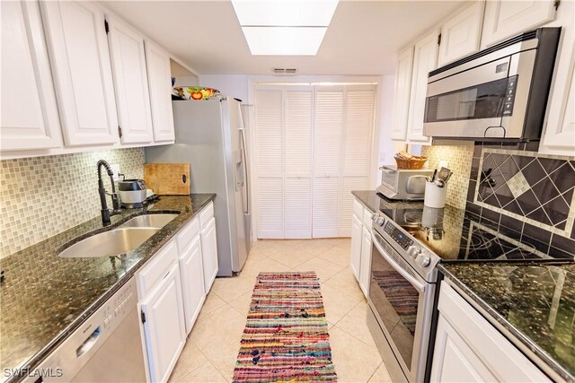 3052 Kings Lake Blvd Unit 7554, Naples, FL 34112 - kitchen featuring stainless steel appliances, white cabinets, backsplash, dark stone counters, and light tile patterned floors