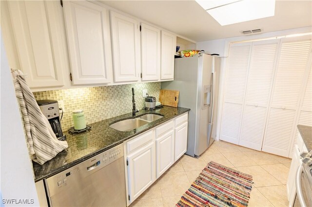 3052 Kings Lake Blvd Unit 7554, Naples, FL 34112 - kitchen featuring stainless steel appliances, dark stone counters, white cabinets, and backsplash