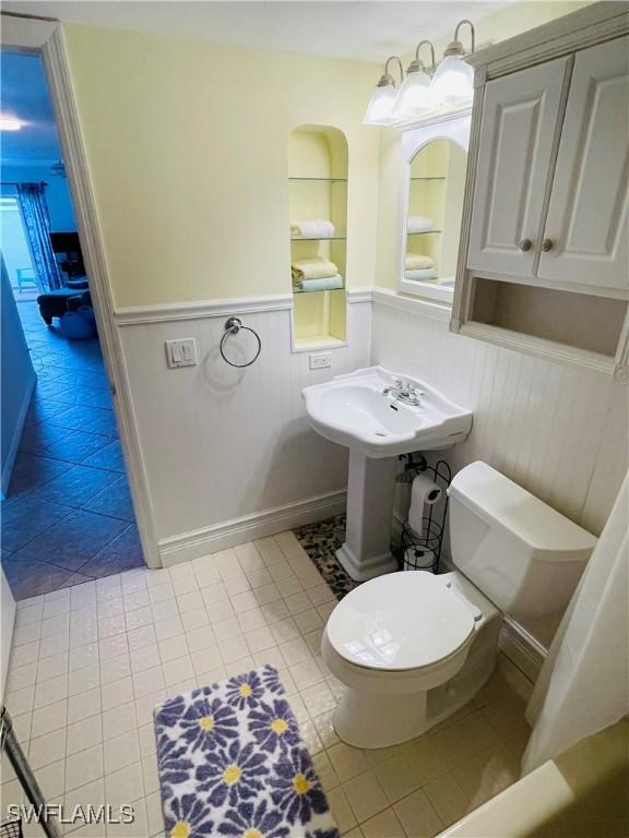 3052 Kings Lake Blvd Unit 7554, Naples, FL 34112 - bathroom featuring a wainscoted wall and tile patterned floors