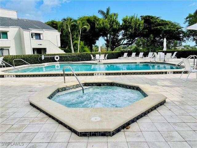 3052 Kings Lake Blvd Unit 7554, Naples, FL 34112 - community pool featuring a community hot tub and a patio