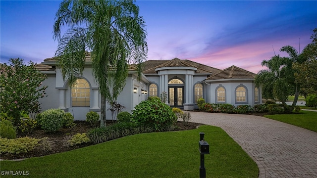 12006 Cypress Links Dr, Fort Myers, FL 33913 - mediterranean / spanish house featuring decorative driveway, french doors, a front yard, and stucco siding