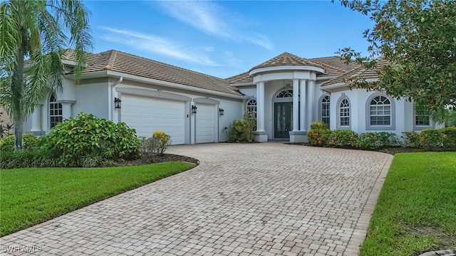 12006 Cypress Links Dr, Fort Myers, FL 33913 - view of front of house featuring stucco siding, decorative driveway, a garage, and a front lawn